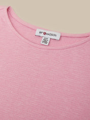 Close-up of a pink ribbed knit top showing the inside neckline with a white brand label that reads 89F MADISON.