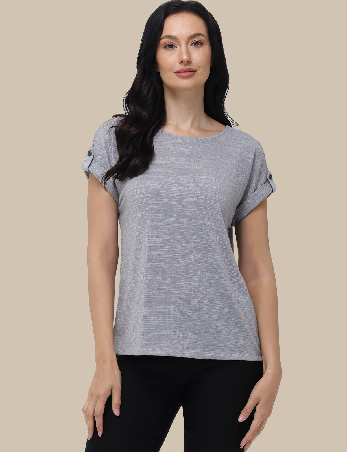 Woman wearing a gray t-shirt against a beige background