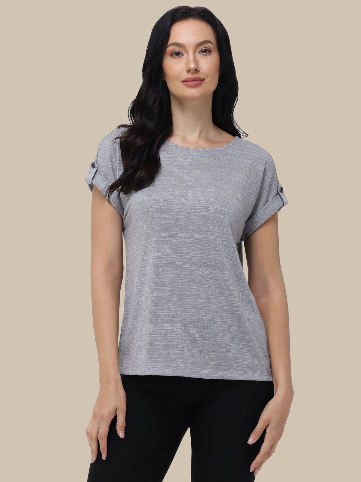 Woman wearing a gray t-shirt against a beige background