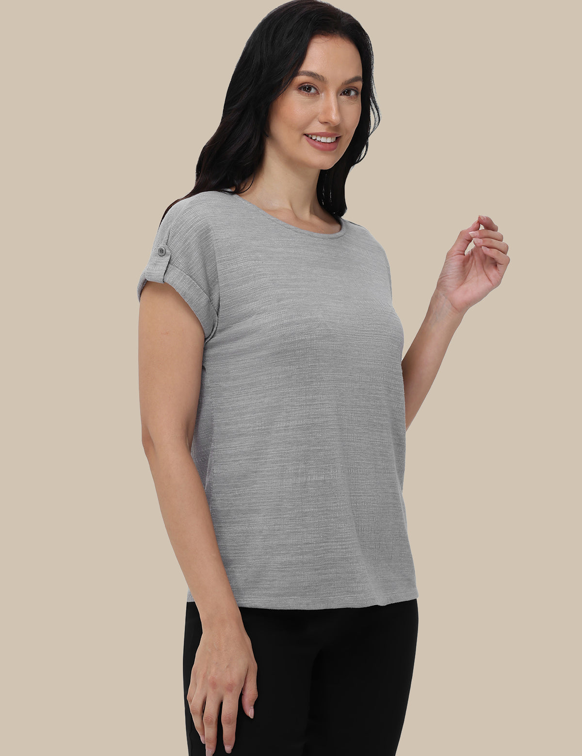 Woman wearing a gray t-shirt against a beige background