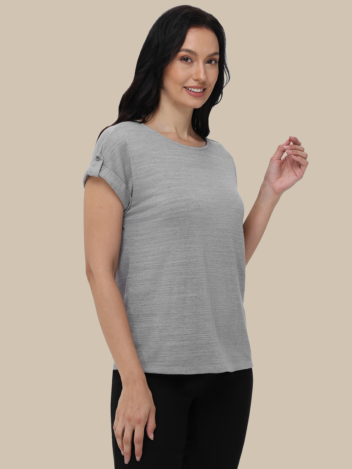 Woman wearing a gray t-shirt against a beige background