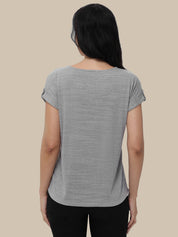 Woman wearing a gray t-shirt against a beige background