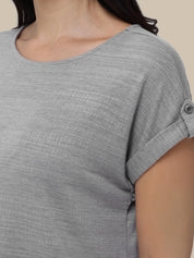 Gray short-sleeve top worn by a person on a beige background