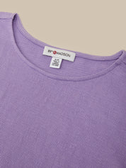 Close-up of a lavender ribbed knit top showing the inside neckline with a white tag that reads 89 Madison.