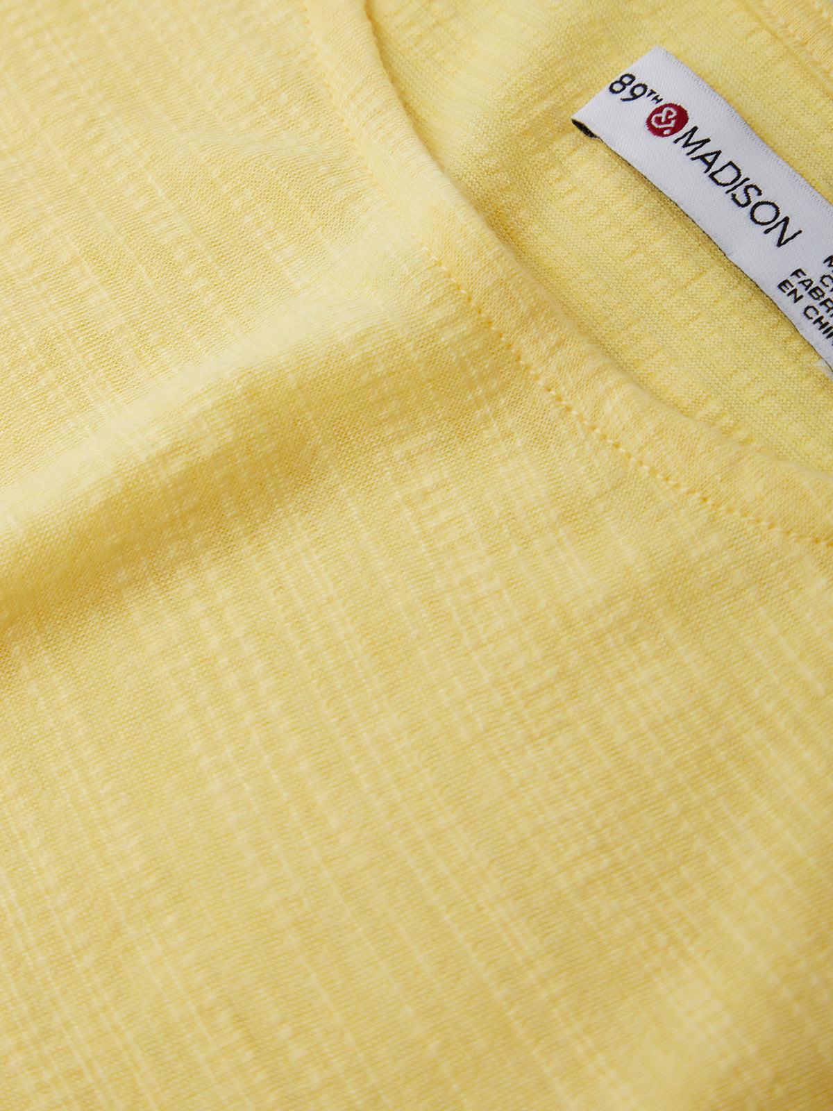 Close-up of a yellow fabric with a label in the corner