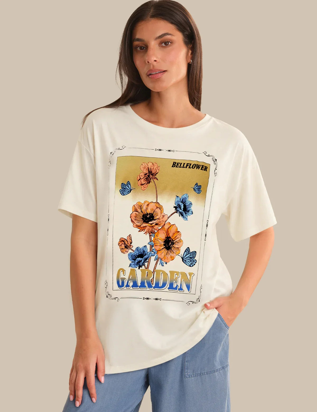 Woman wearing a white t-shirt with a floral graphic and text on a beige background