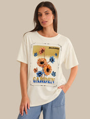 Woman wearing a white t-shirt with a floral graphic and text on a beige background