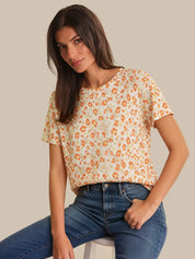 Woman wearing a leopard print top and blue jeans on a beige background