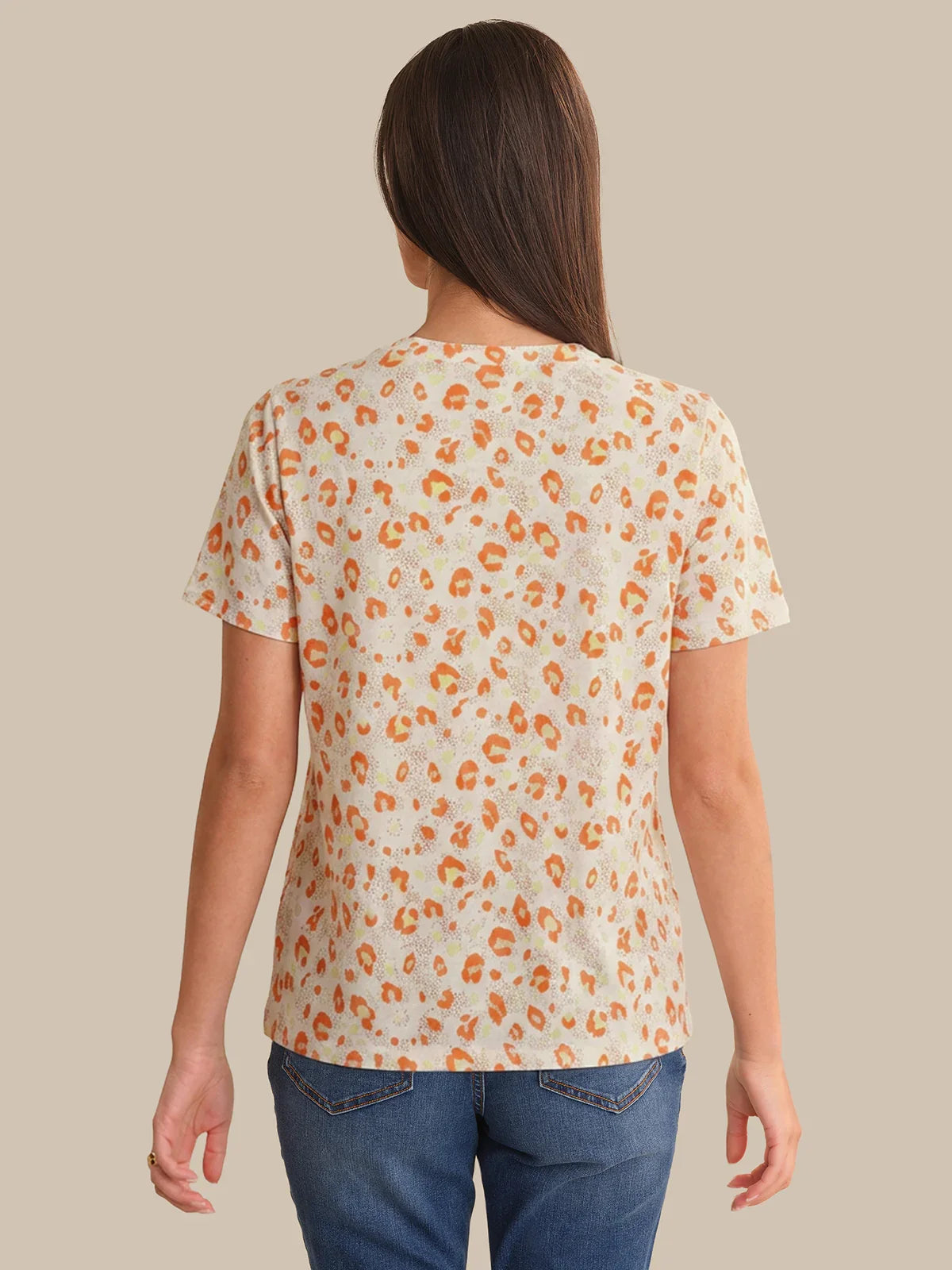 Person wearing a leopard print t-shirt against a beige background
