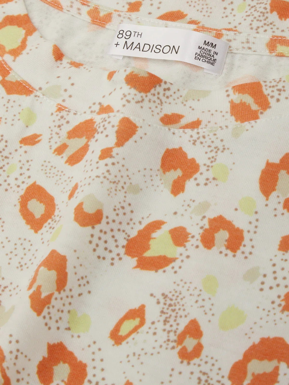 Fabric with orange and yellow pattern and '89th Madison' label.
