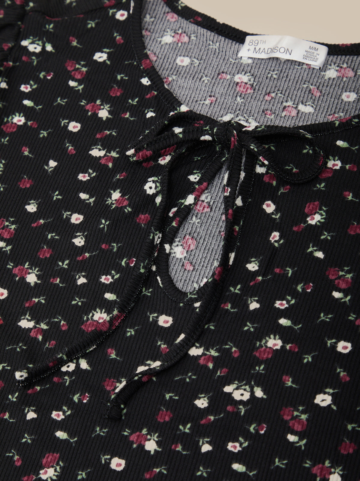 Floral patterned dress with a tie neckline and visible label.