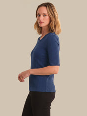 Woman wearing a blue tops against a beige background