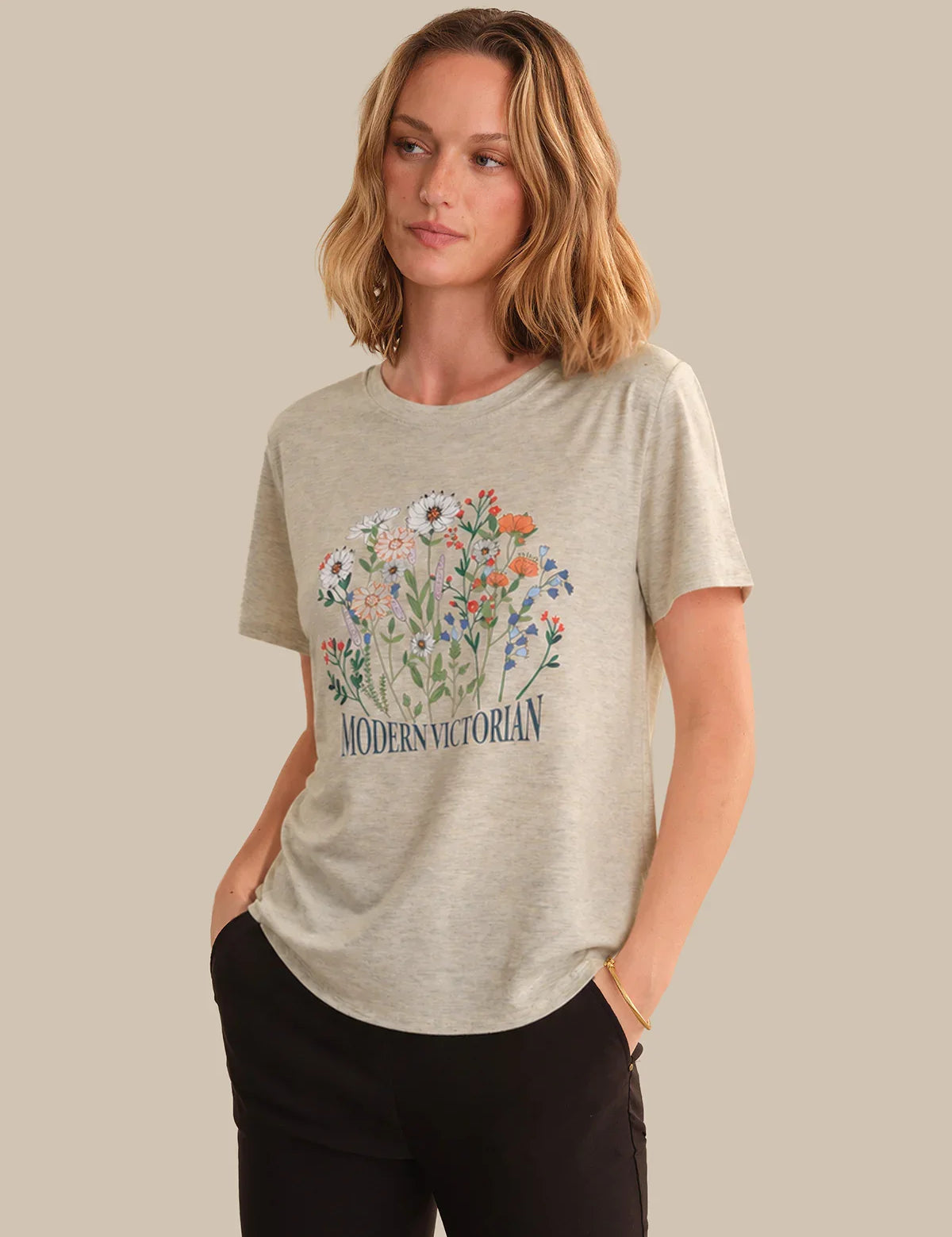 Woman wearing a beige t-shirt with floral design and 'Modern Victorian' text on a beige background