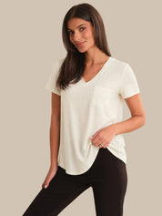 Woman wearing a white blouse and black pants on a beige background