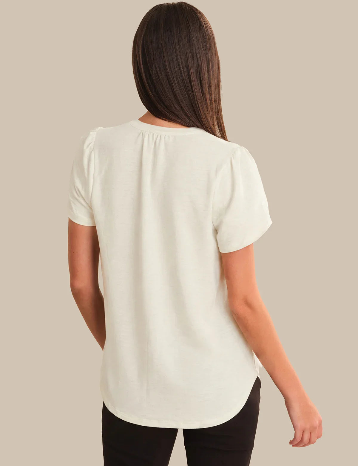 Woman wearing a white blouse against a beige background