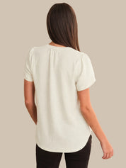 Woman wearing a white blouse against a beige background