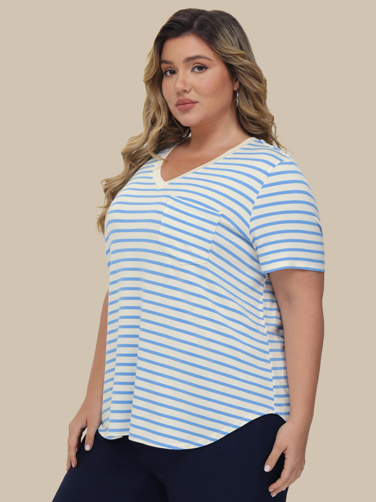 Woman wearing a blue and white striped shirt against a beige background
