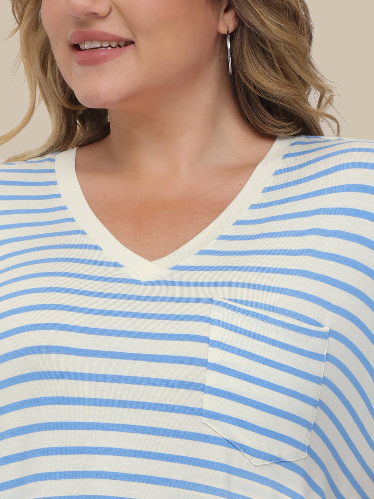 Close-up of a person wearing a blue and white striped shirt with a pocket.