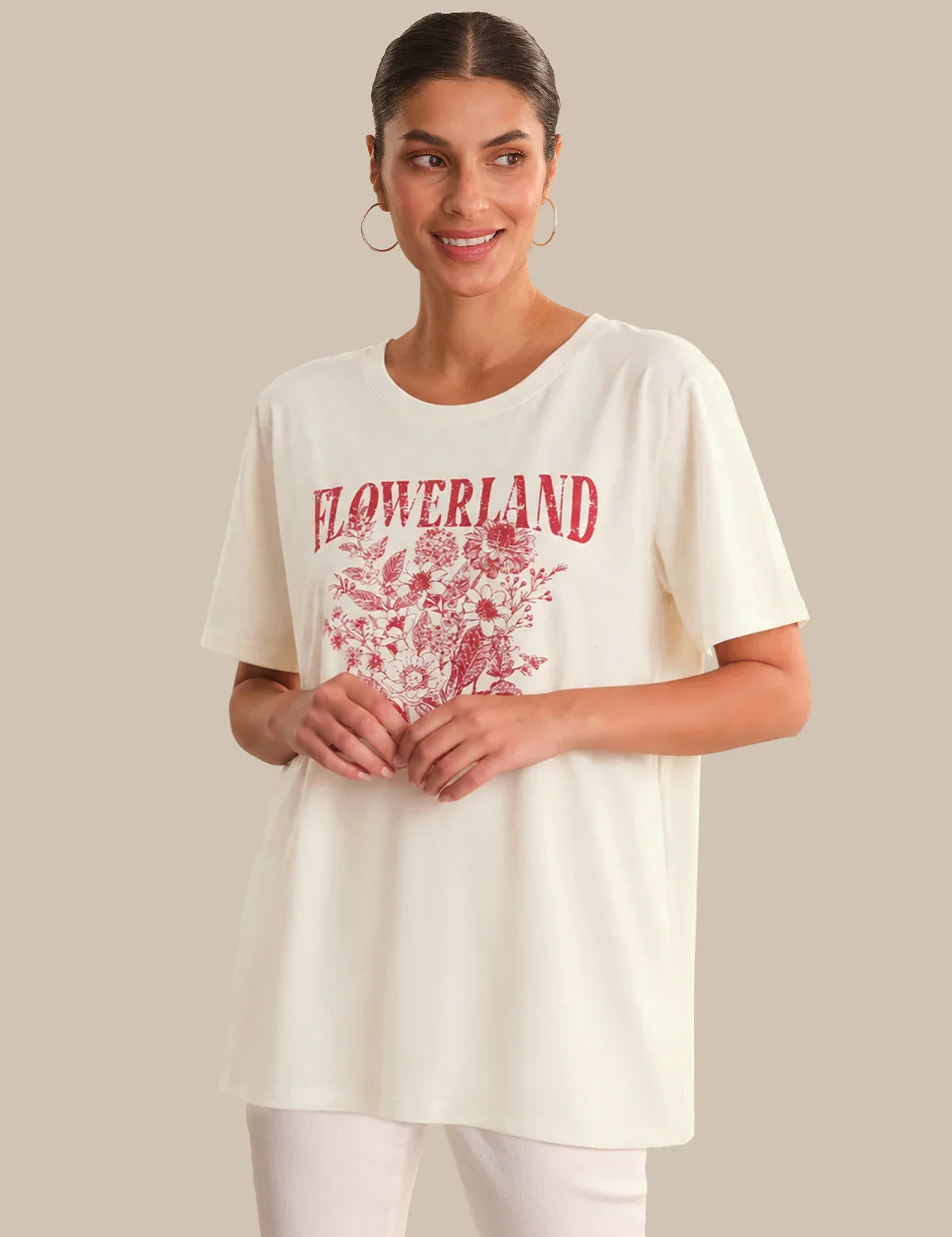 Woman wearing a white t-shirt with red 'FLOWERLAND' print on a beige background