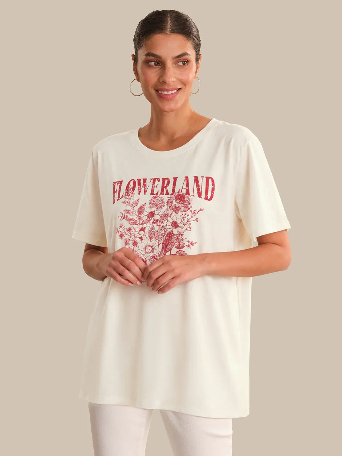 Woman wearing a white t-shirt with red 'FLOWERLAND' print on a beige background