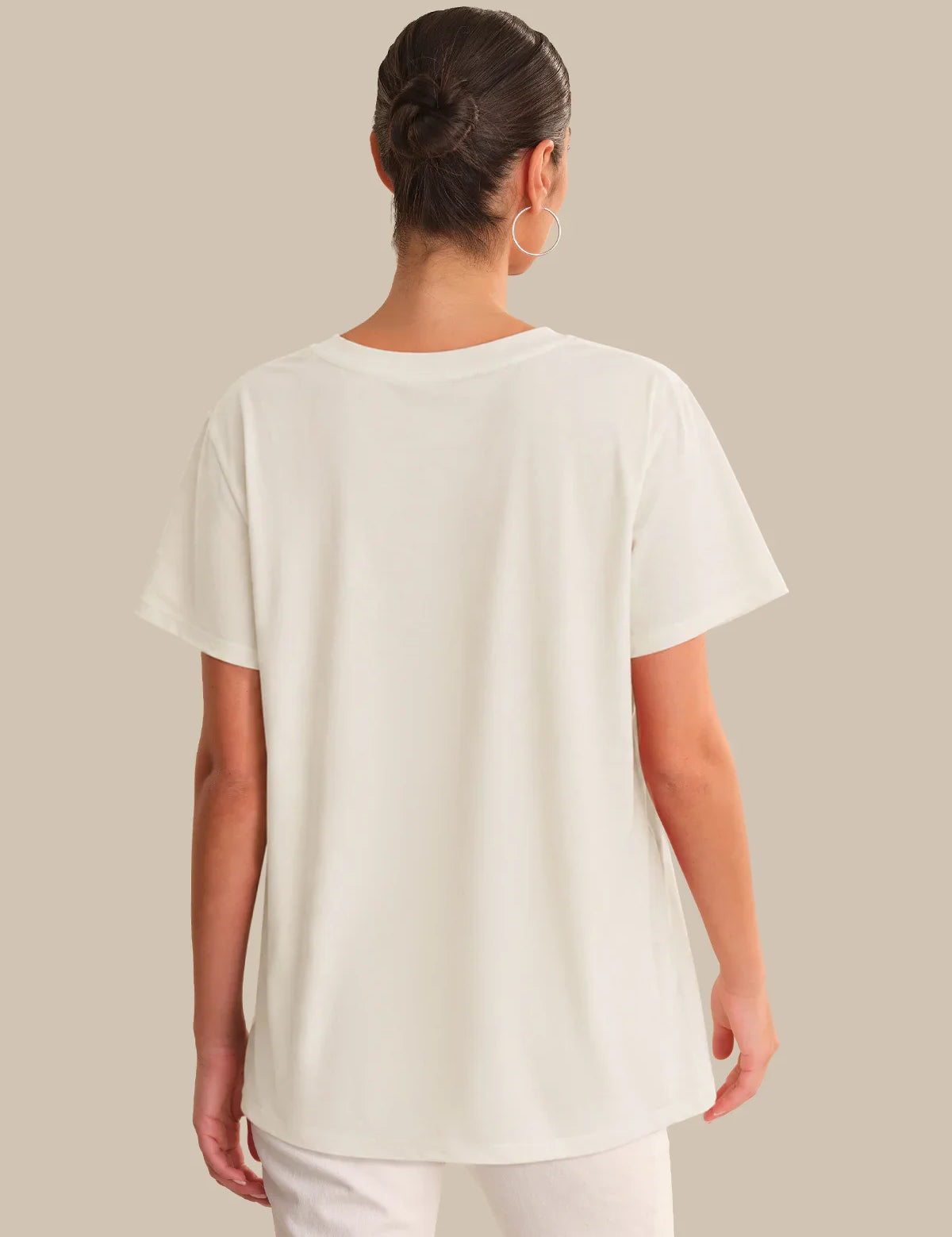 Person wearing a white t-shirt against a beige background