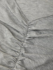 Close-up of gray fabric with a focus on texture and stitching.