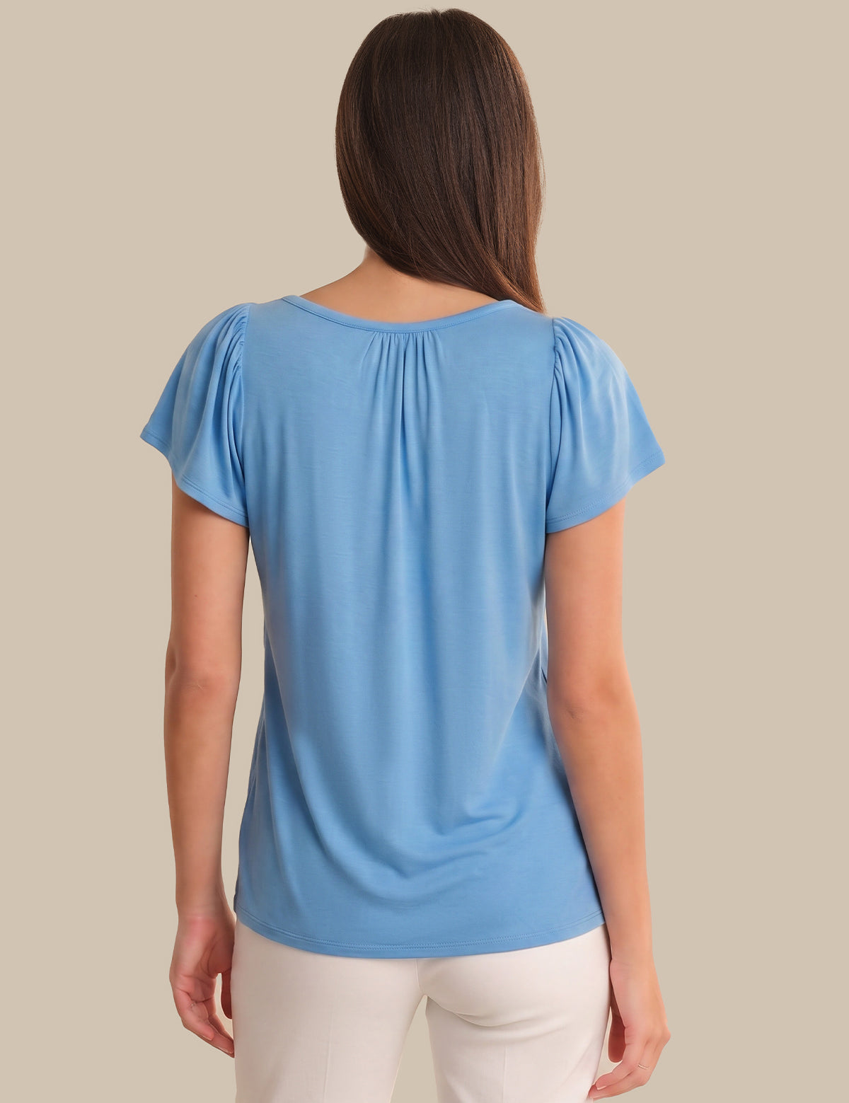 Woman wearing a blue top with a plain background