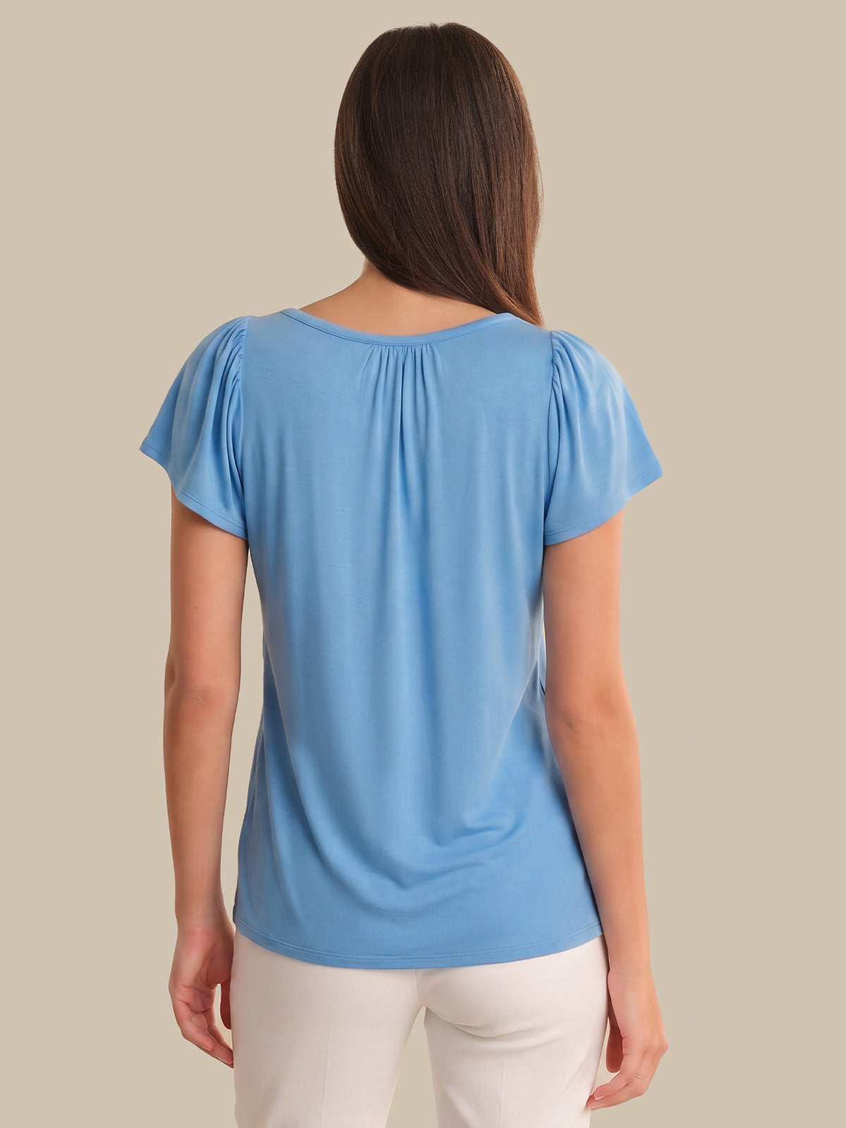 Woman wearing a blue top with a plain background