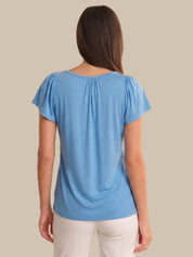 Woman wearing a blue top with a plain background