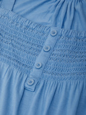 Close-up of a blue dress with smocked waist and button details