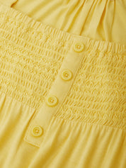 Close-up of a yellow fabric with smocked texture and button details