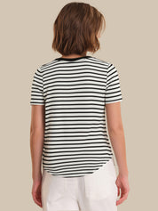 Person wearing a black and white striped t-shirt on a beige background