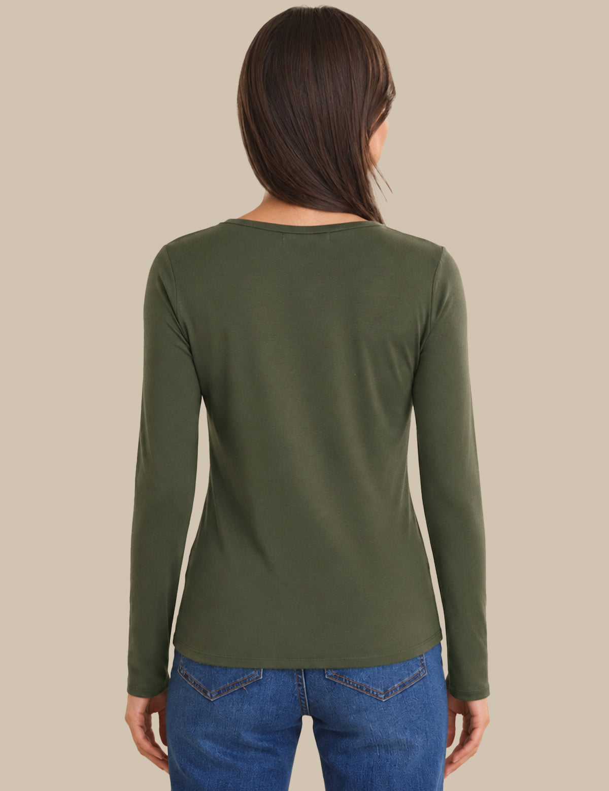 A woman viewed from the back wearing a fitted long-sleeve crew-neck top in olive green, paired with blue jeans, against a plain beige studio background.