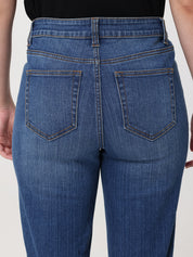 Blue jeans worn by a person on a plain background