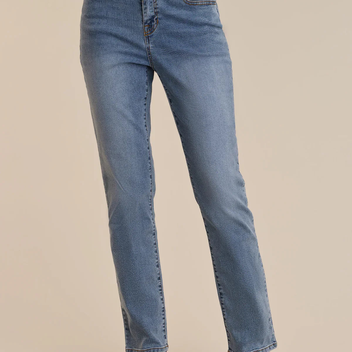 Blue jeans worn by a person on a beige background