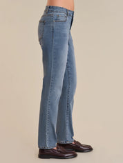 Blue jeans worn by a person on a beige background
