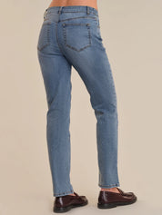 Blue jeans worn by a person on a beige background