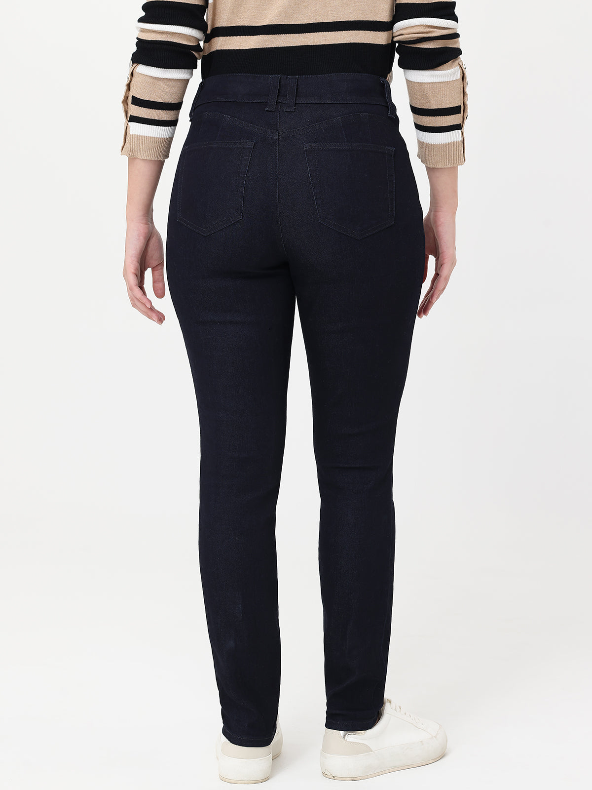 Person wearing navy jeans with a striped sweater on a white background