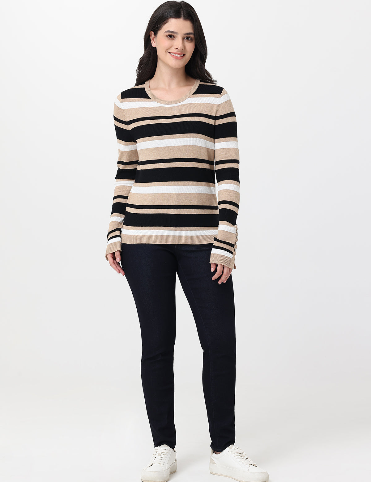 Woman wearing a striped sweater and navy jeans on a white background