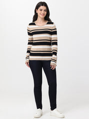 Woman wearing a striped sweater and navy jeans on a white background