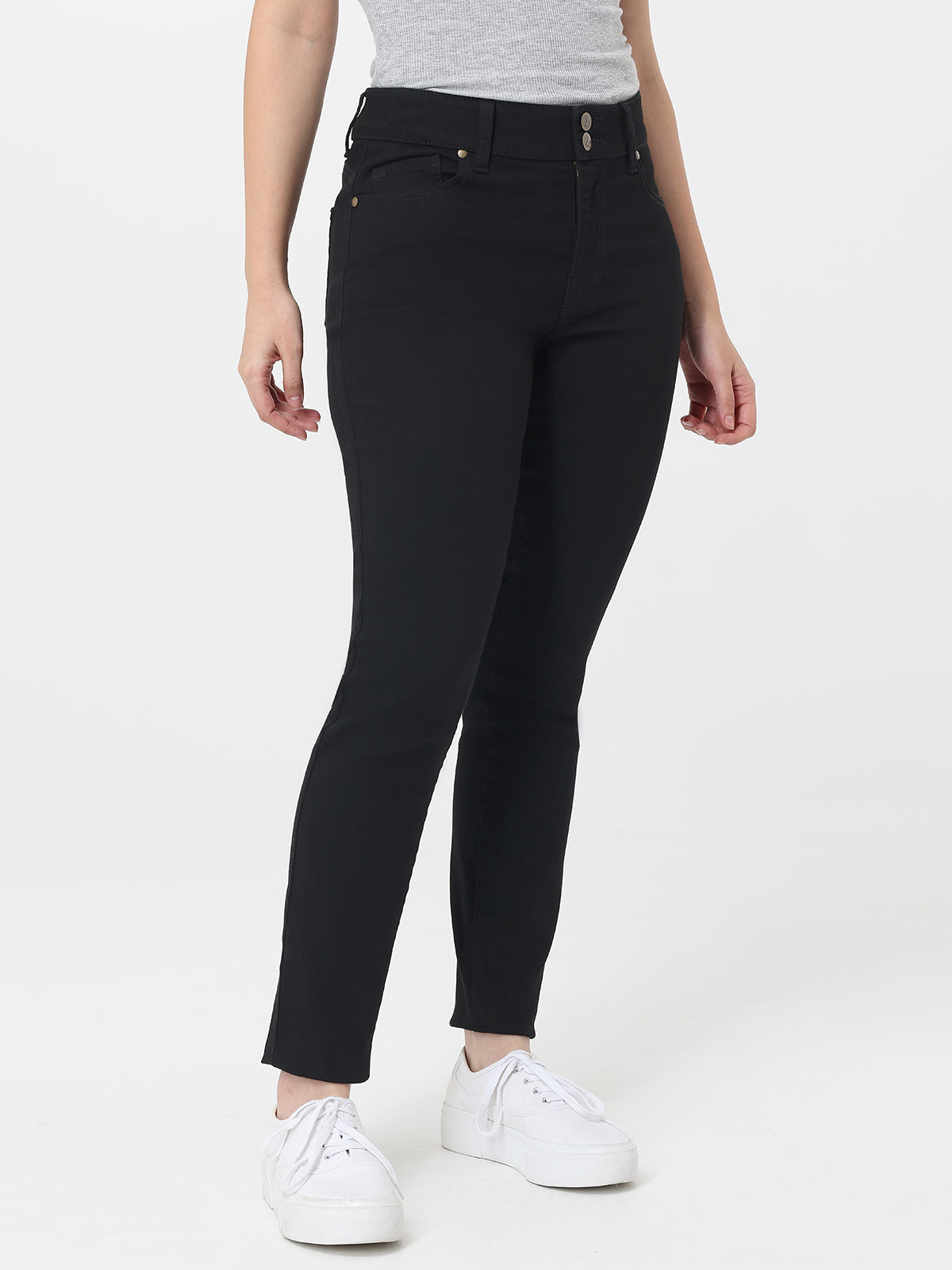 Person wearing black jeans and white sneakers on a white background