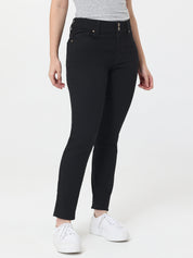 Person wearing black jeans and white sneakers on a white background