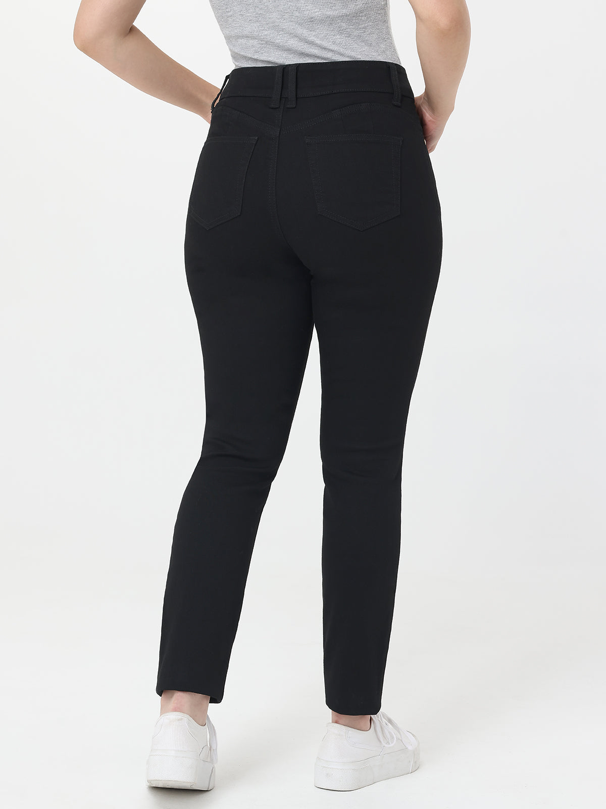 Person wearing black jeans on a white background