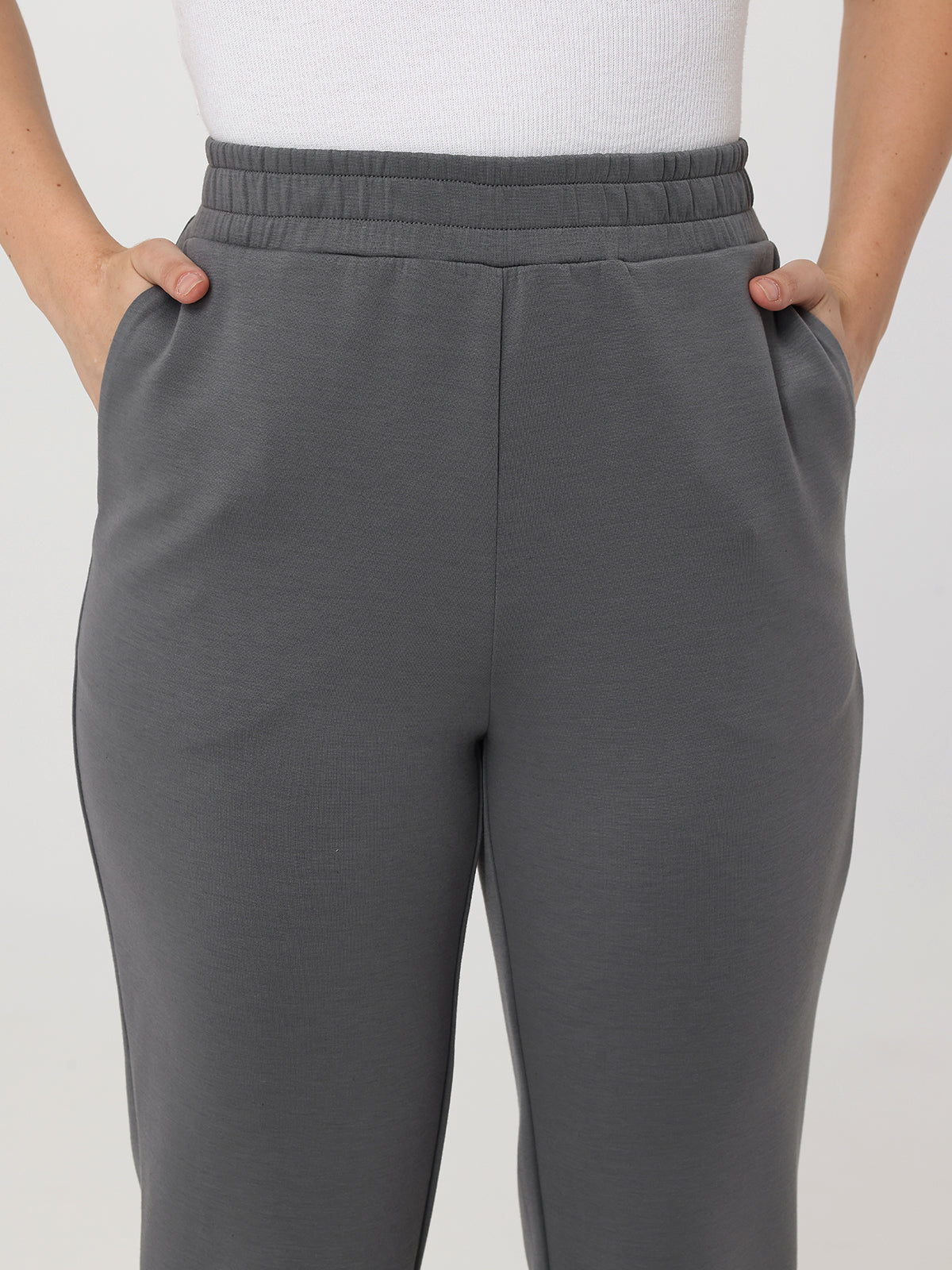 Gray pants worn by a person on a plain background