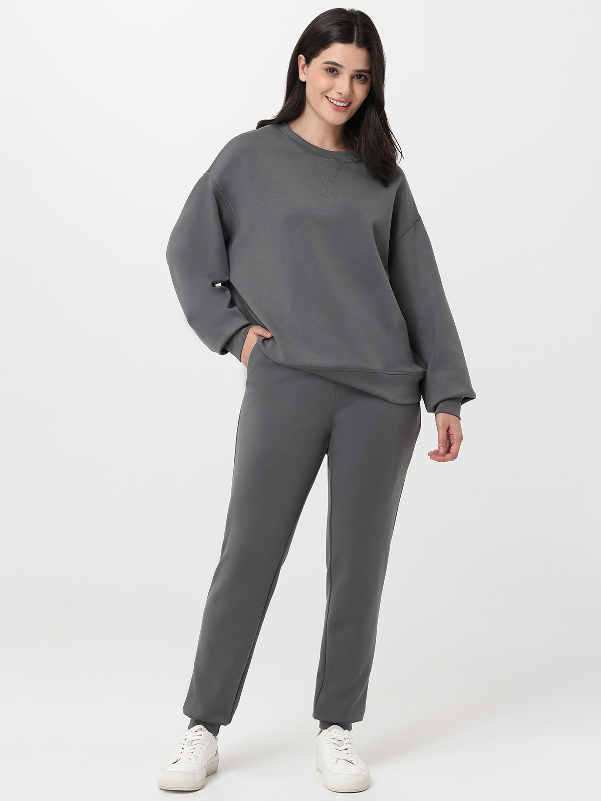 Woman wearing a gray tracksuit on a white background