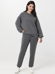 Woman wearing a gray tracksuit on a white background