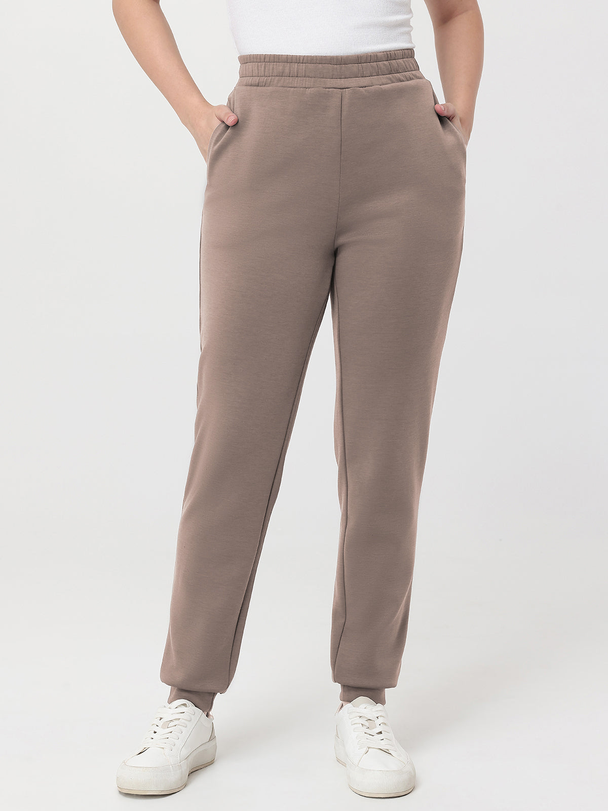 Beige pants worn by a person on a white background