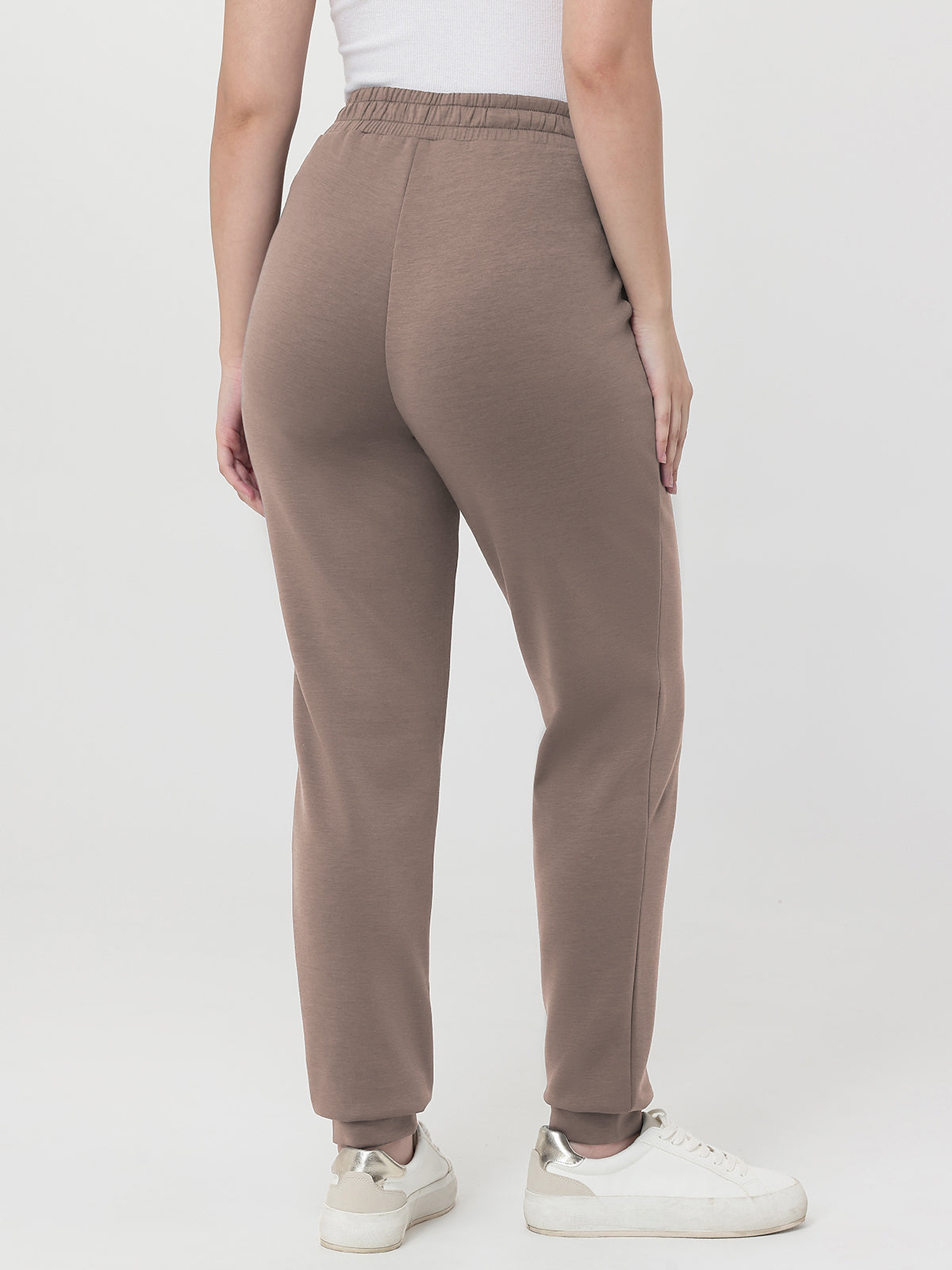 Brown pants worn by a person on a white background