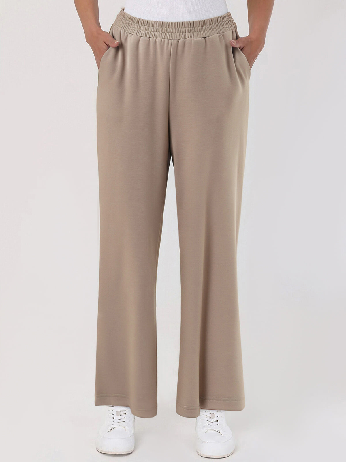 Beige pants worn by a person on a white background