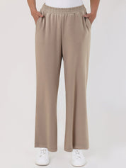 Beige pants worn by a person on a white background